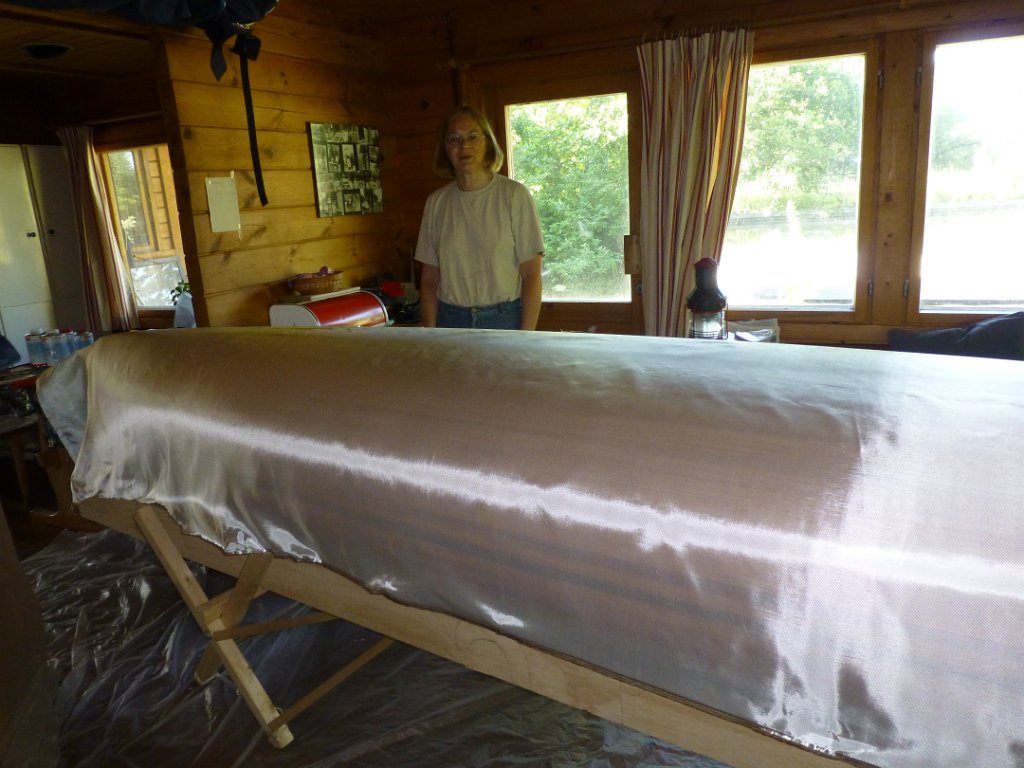 canoe epoxy woodcore.JPG - En dan volgt een spannende klus: de boot inpakken in glasmat en die in de epoxy zetten. Er mogen geen vouwen in de glasmat zitten en er mogen geen luchtbellen onder komen.