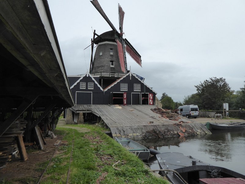 P1090292.JPG - De molen in volle glorie. Langs de helling worden de stammen opgetrokken. De rommel is afgeschraapte bast.