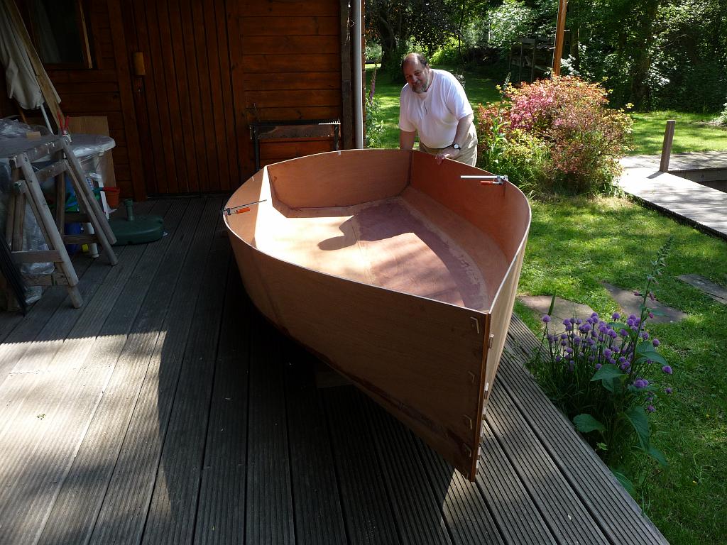 0381_Buiten.JPG - De bouwstelling is nu een sta-in-de-weg, dus die moet eruit. Daarvoor tillen we eerst ons bootje naar buiten. Zijn openluchtdoop! Onbewerkte epoxy kan niet tegen UV licht, dus daarna gaat hij snel weer naar binnen.