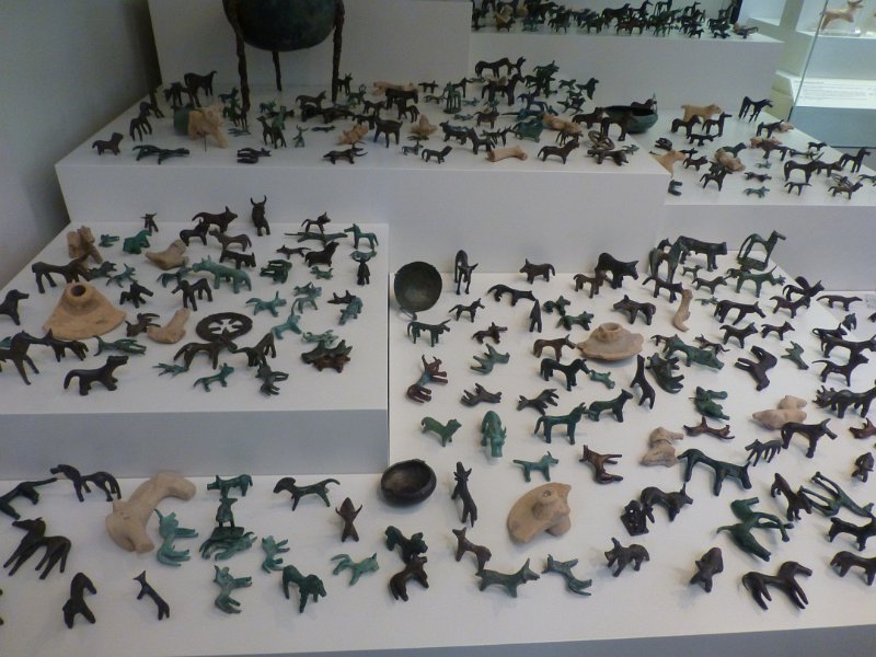 P1090394.JPG - Duizenden votiefbeeldjes uit alle tijden. Dit is een deel van alle paardjes uit de Myceense tijd die het museum heeft. Het Allard Pierson is blij met vier van die paarden ... 